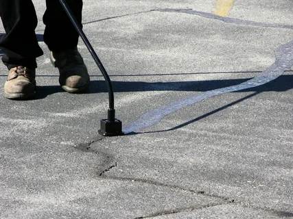 a men sealing a asphalt