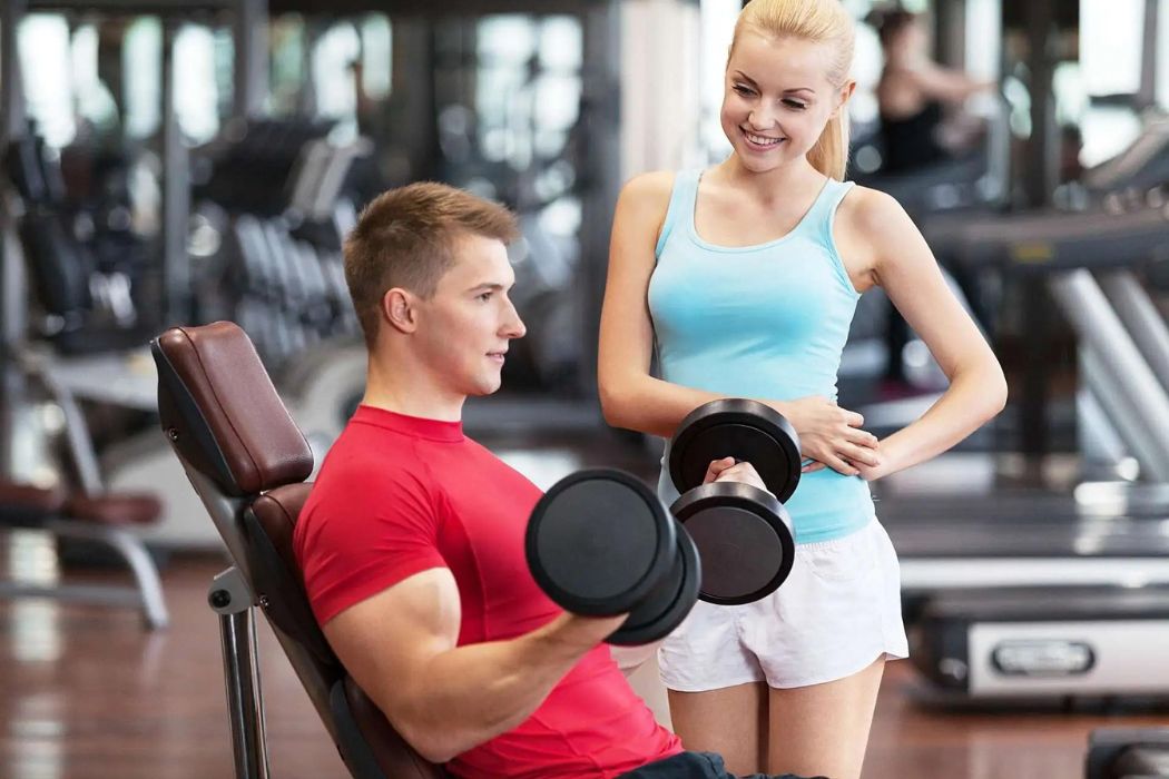 man and woman are exercising together in a gym, showcasing fitness dedication